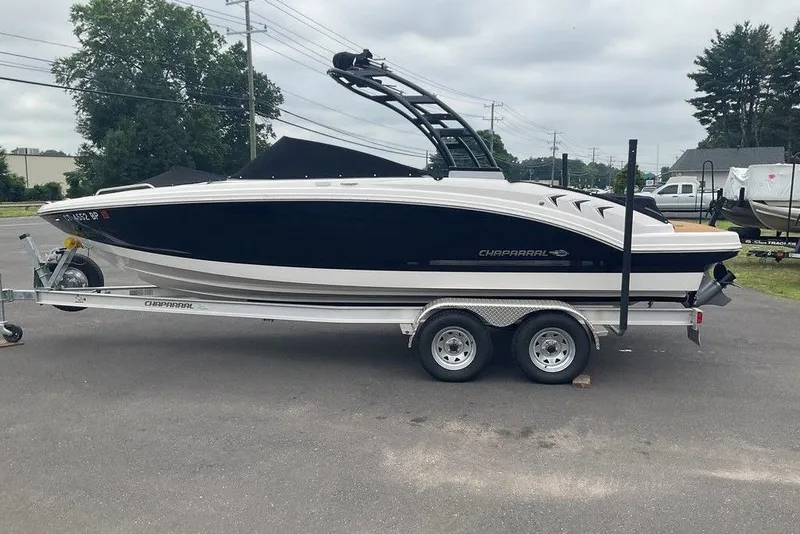 Slide: The Image of 2023 Chaparral 23 SSi boat on trailer, parked outdoors on a cloudy day. - 3