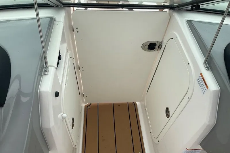Slide: The Image of 2023 Chaparral 23 SSi boat interior with storage compartments and teak flooring. - 32