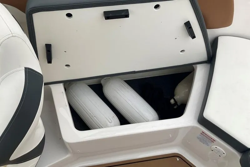 Slide: The Image of Open storage compartment in 2023 Chaparral 23 SSi boat with fenders inside. - 34