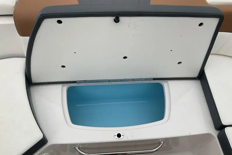 Slide: The Image of Open storage compartment on 2023 Chaparral 23 SSi boat, featuring a blue interior. - 36