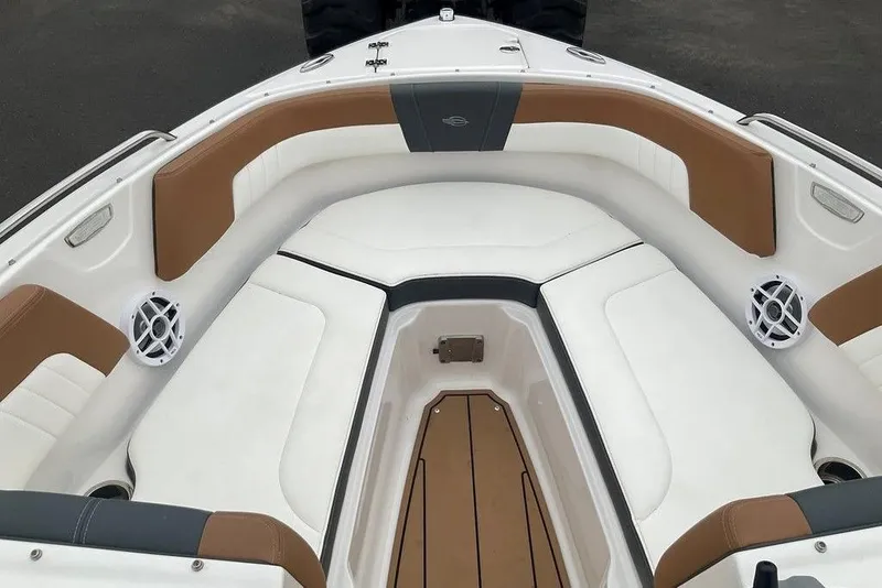 Slide: The Image of 2023 Chaparral 23 SSi boat interior with white and brown seating, speakers, and storage. - 37