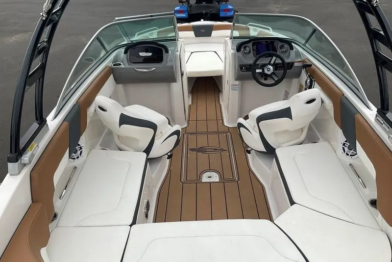 Slide: The Image of 2023 Chaparral 23 SSi boat interior with white seating and brown flooring. - 7