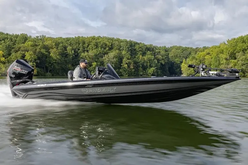 The Image of 2026 Phoenix 921 Elite X boat speeding on a lake with lush forest background. - 1