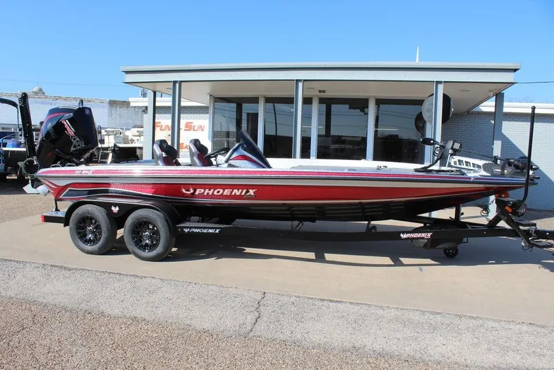 Slide: The Image of 2026 Phoenix 921 Elite X boat on trailer, parked outside dealership. - 2