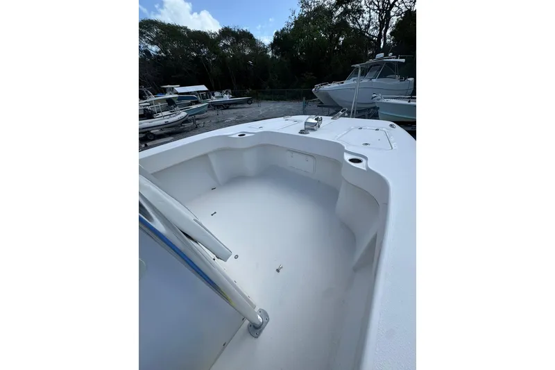 Slide: The Image of 2019 Twin Vee 26 Center Console boat, spacious deck, parked among other boats. - 6