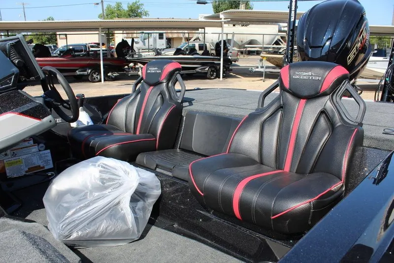 Slide: The Image of 2026 Skeeter ZXE20 boat interior with black and red seats, steering wheel, and engine. - 14