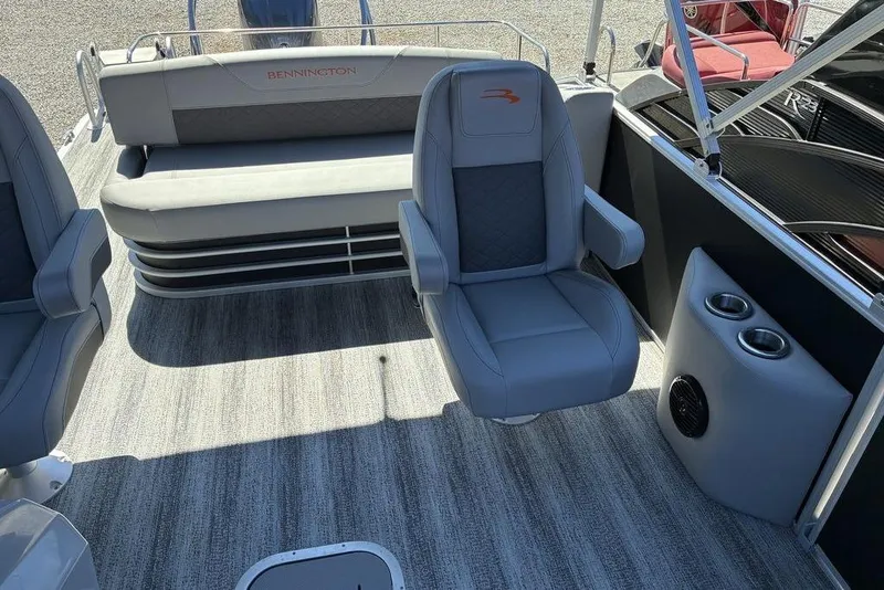 Slide: The Image of 2025 Bennington 22 SX Swingback boat interior with gray seating and cup holders. - 5