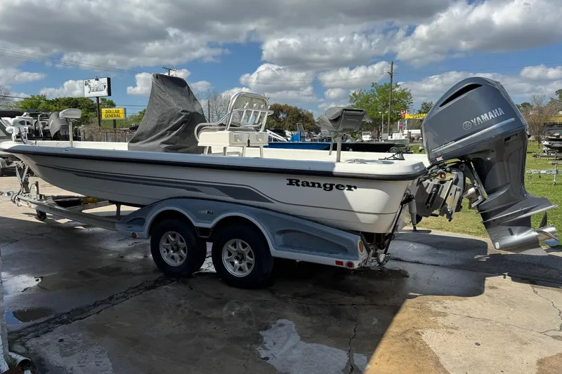 The Image of 2011 Ranger 2400 Bay Ranger boat with Yamaha motor on trailer, parked outdoors. - 1