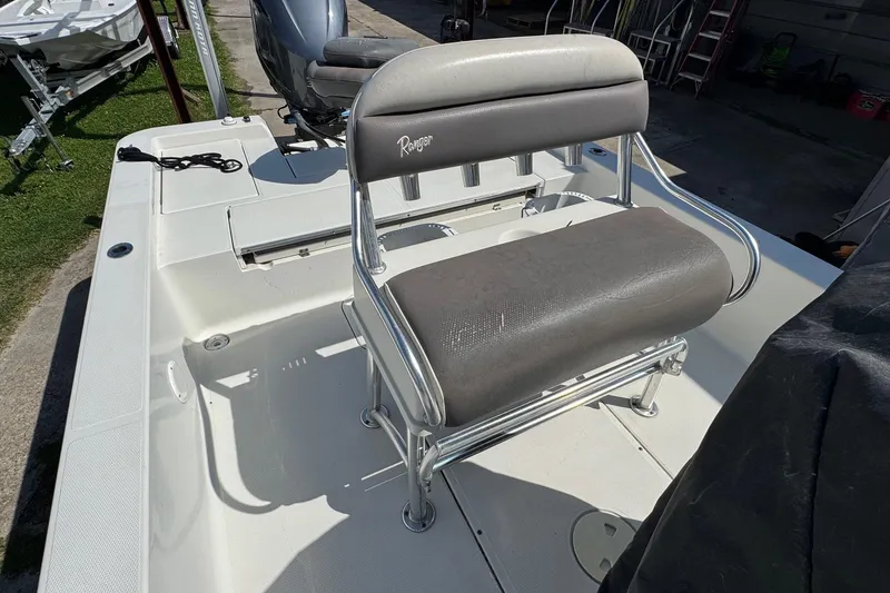 Slide: The Image of 2011 Ranger 2400 Bay Ranger boat with seating and motor, parked outdoors. - 12