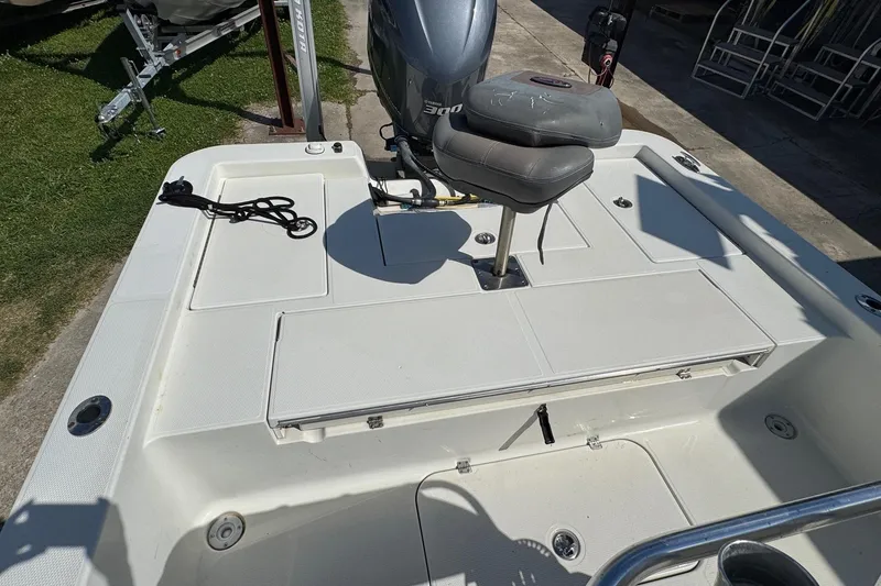 Slide: The Image of 2011 Ranger 2400 Bay Ranger boat deck with seating and motor, parked outdoors. - 13