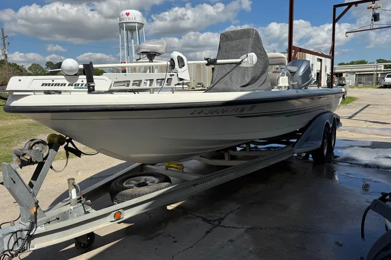 Slide: The Image of 2011 Ranger 2400 Bay Ranger boat on trailer, parked outdoors under blue sky. - 2