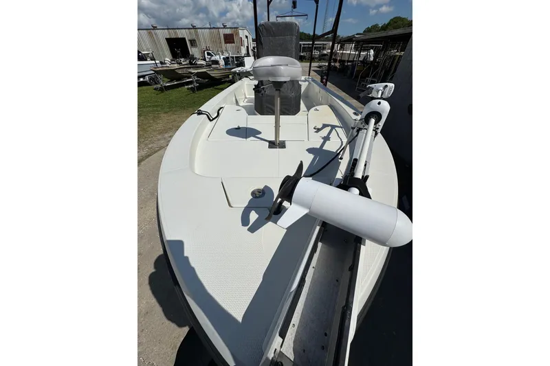 Slide: The Image of 2011 Ranger 2400 Bay Ranger boat with trolling motor, docked outdoors under a clear sky. - 6