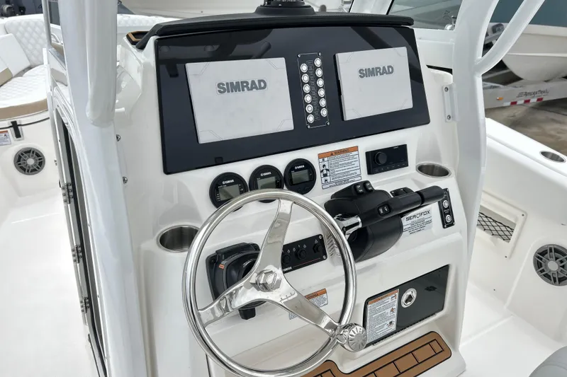 Slide: The Image of 2026 Sea Fox 268 Commander boat dashboard with Simrad displays and steering wheel. - 16