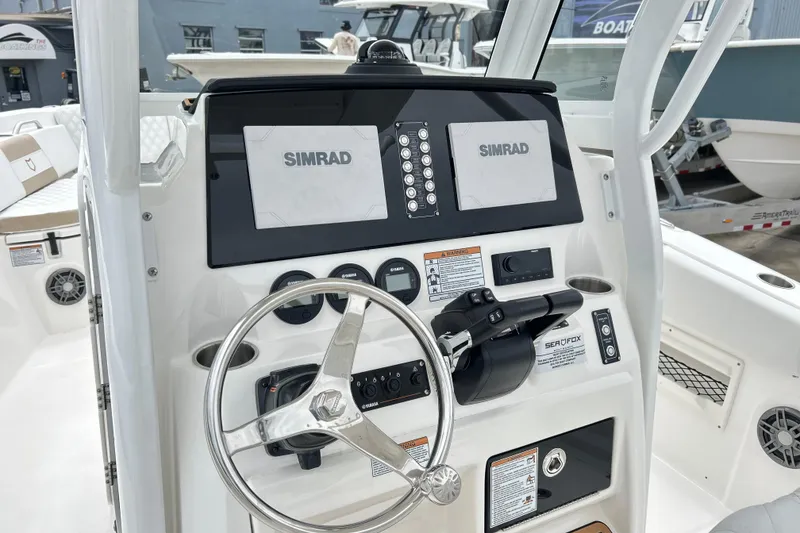 Slide: The Image of 2026 Sea Fox 268 Commander boat dashboard with Simrad displays and steering wheel. - 20