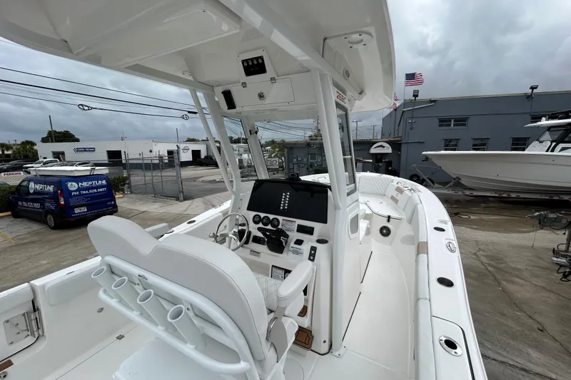 Slide: The Image of 2026 Sea Fox 268 Commander boat interior with helm, seats, and dashboard in a marina setting. - 44