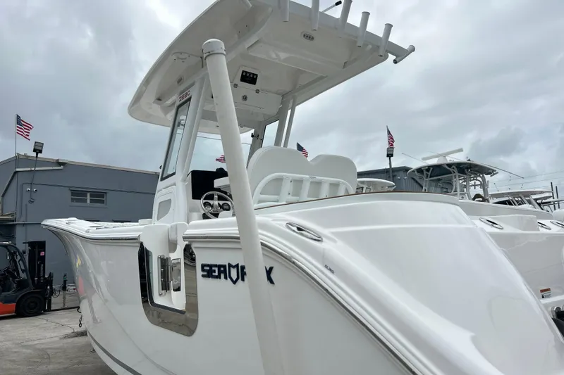 Slide: The Image of 2026 Sea Fox 268 Commander boat displayed outdoors with American flags in the background. - 47