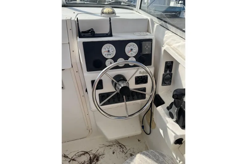 Slide: The Image of Control panel of a 2000 Sport-Craft 241 Walk Around boat with steering wheel. - 14