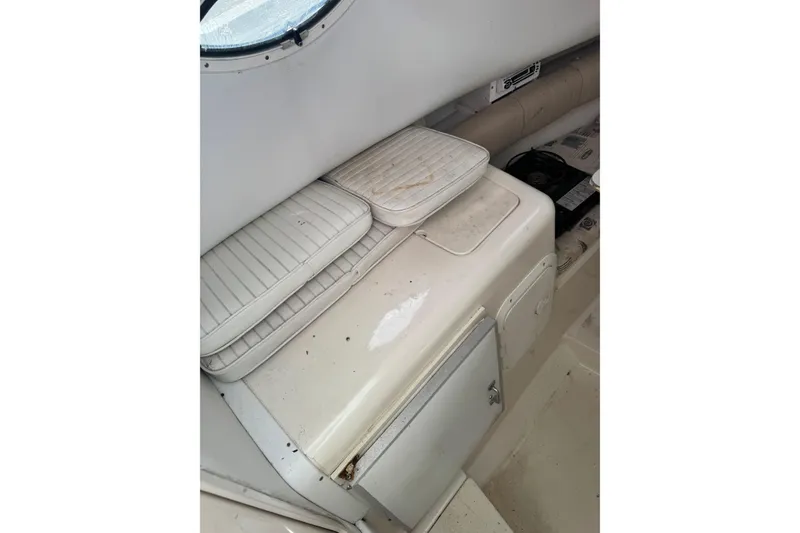 Slide: The Image of 2000 Sport-Craft 241 Walk Around cabin interior with white seating and storage. - 15