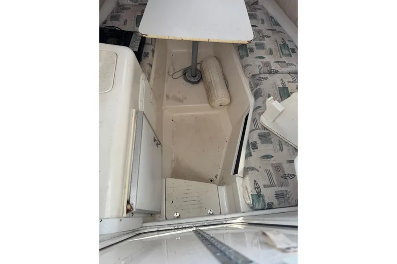 Slide: The Image of Interior of 2000 Sport-Craft 241 Walk Around boat with table and patterned seating. - 18