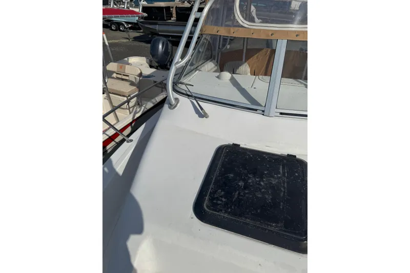 Slide: The Image of 2000 Sport-Craft 241 Walk Around boat deck with windshield and seating area. - 19