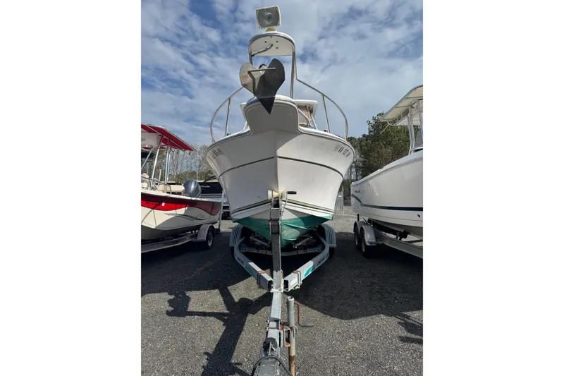 Slide: The Image of 2000 Sport-Craft 241 Walk Around boat on trailer, parked between two other boats. - 3