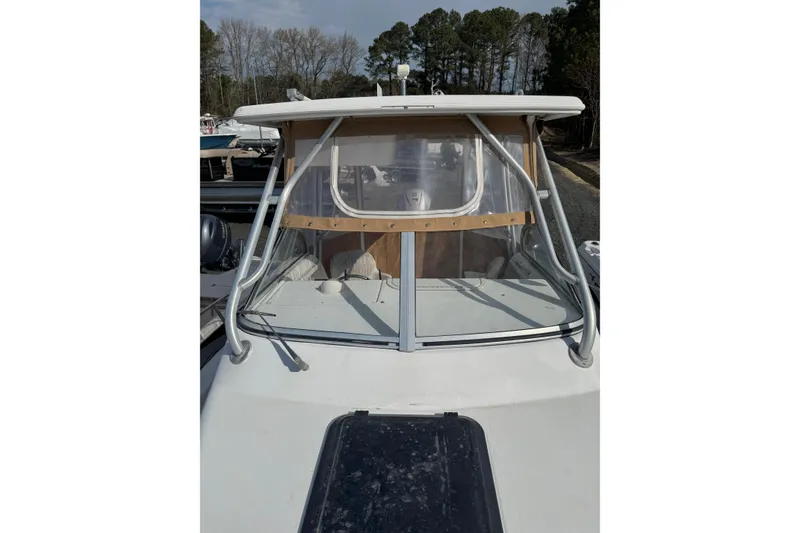 Slide: The Image of 2000 Sport-Craft 241 Walk Around boat with windshield and canopy, docked outdoors. - 6