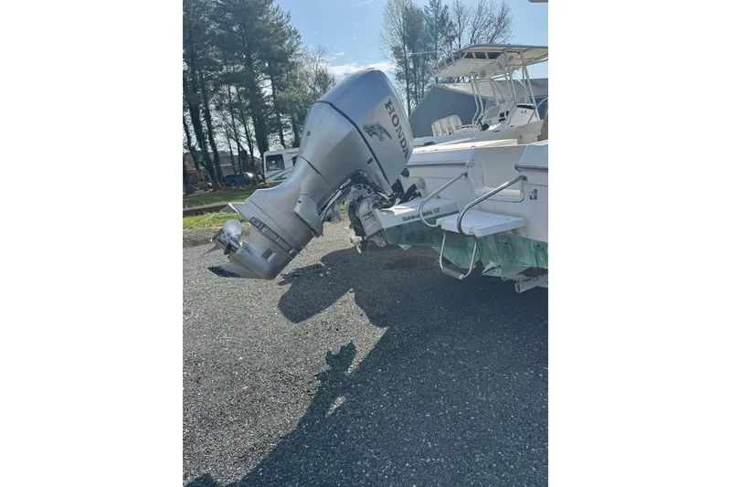 Slide: The Image of 2000 Sport-Craft 241 Walk Around boat with Honda outboard motor in a sunny outdoor setting. - 7