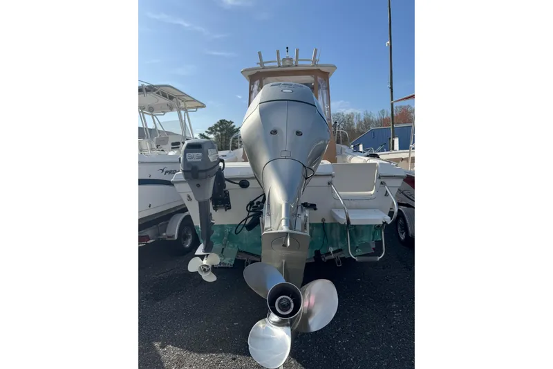 Slide: The Image of 2000 Sport-Craft 241 Walk Around boat with powerful outboard motor, docked outdoors. - 8