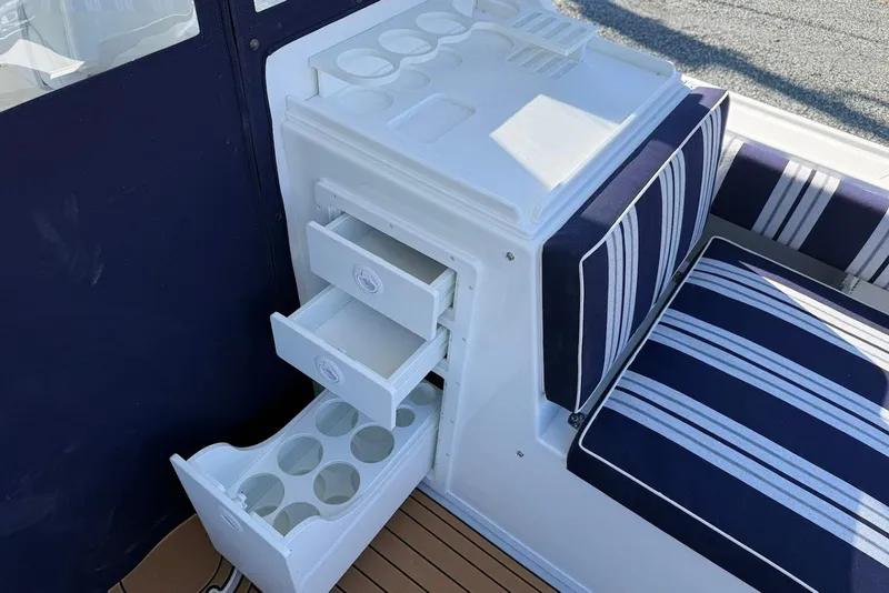 Slide: The Image of Steiger Craft 28 Annapolis 2026 with storage and striped cushions. - 14