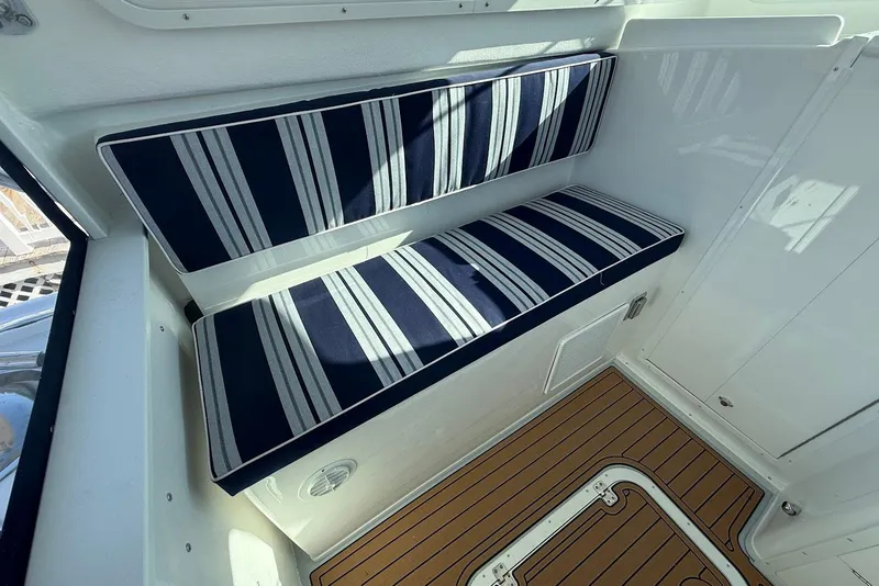 Slide: The Image of Interior of Steiger Craft 28 Annapolis 2026 with striped seat cushions. - 16