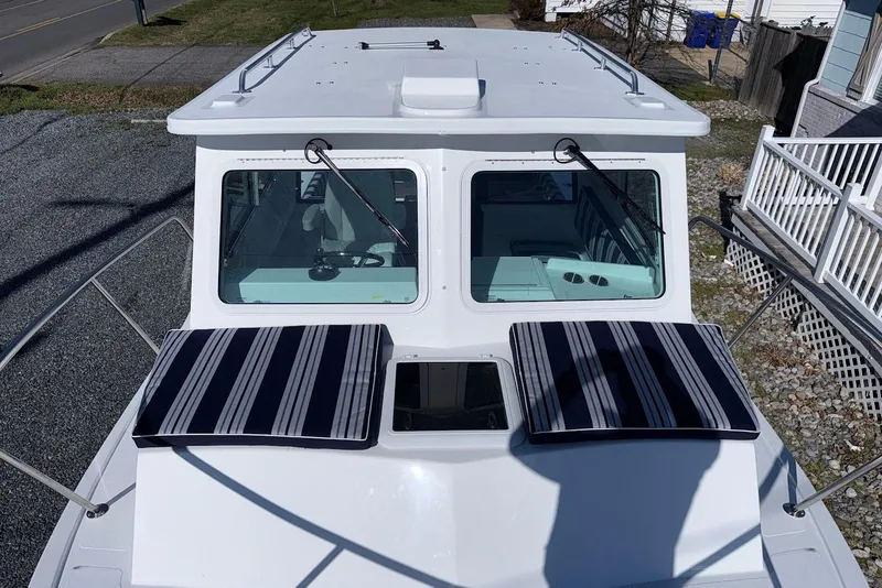 Slide: The Image of Steiger Craft 28 Annapolis 2026 with striped cushions on the deck. - 24