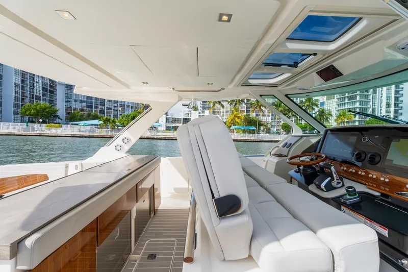 Slide: The Image of 2024 Tiara Yachts 43 LS interior with luxurious seating and modern helm, dockside view. - 29