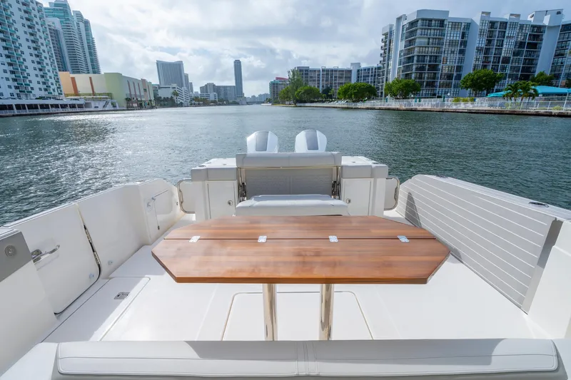 Slide: The Image of 2024 Tiara Yachts 43 LS luxury boat with wooden table, cityscape in background. - 40