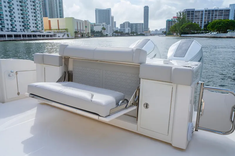 Slide: The Image of 2024 Tiara Yachts 43 LS luxury boat with seating and twin engines, docked in urban marina. - 44