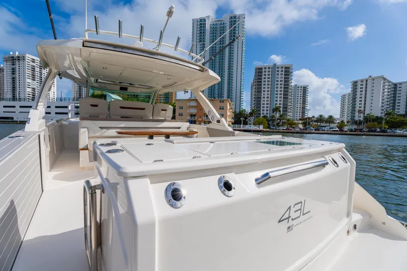 Slide: The Image of 2024 Tiara Yachts 43 LS luxury boat docked near city skyline. - 47