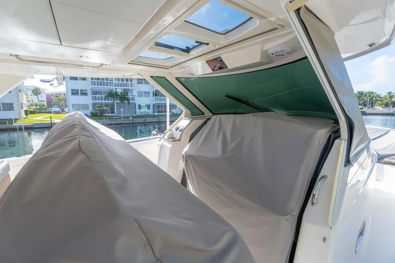 Slide: The Image of 2024 Tiara Yachts 43 LS interior with covered seating and waterfront view. - 52