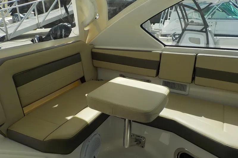 Slide: The Image of 2020 Pursuit OS 355 Offshore boat interior with beige seating and compact table. - 12