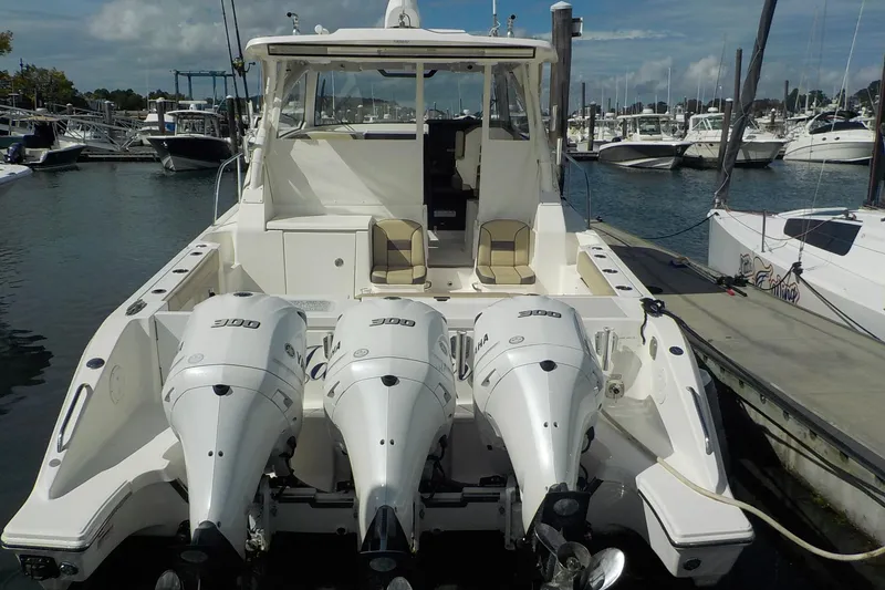 Slide: The Image of 2020 Pursuit OS 355 Offshore boat with triple outboard engines docked at marina. - 2
