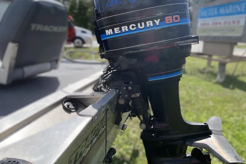 Slide: The Image of 1994 Tracker Pro Guide V-17 SC with Mercury 80 outboard motor in a sunny outdoor setting. - 5
