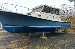Slide: The Image of 1998 Eastern 35 Casco Bay boat on stands, blue hull, parked outdoors. - 18