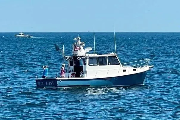 Slide: The Image of Eastern 35 Casco Bay boat from 1998 on open water, with people on deck. - 4