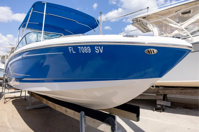 The Image of 2021 Chaparral 21 SSi OB boat with blue hull, docked under a sunny sky. - 0
