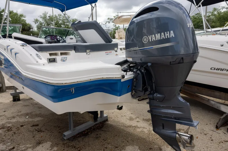 Slide: The Image of 2021 Chaparral 21 SSi OB boat with Yamaha outboard motor, parked on sandy ground. - 2