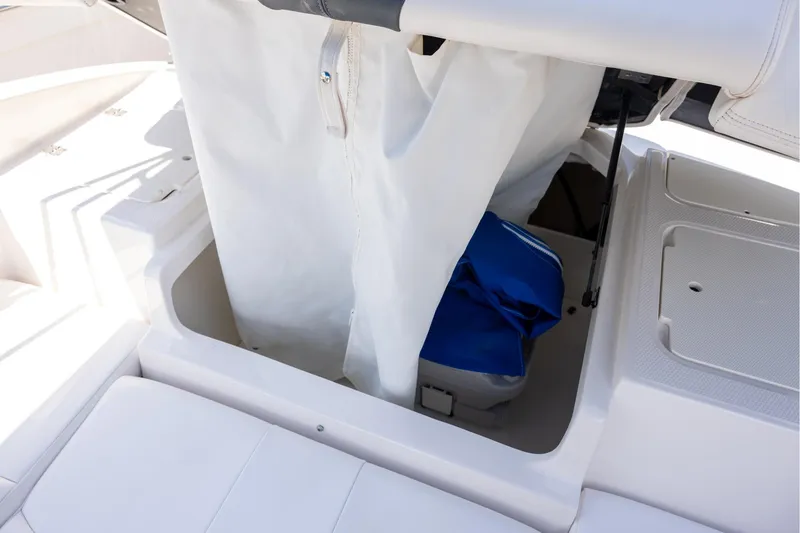 Slide: The Image of Storage compartment in 2021 Chaparral 21 SSi OB boat, featuring white and blue interior. - 6