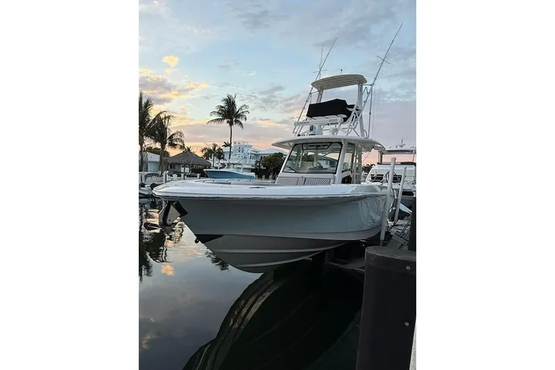 The Image of 2023 Boston Whaler 380 Outrage docked at sunset with palm trees in the background. - 0