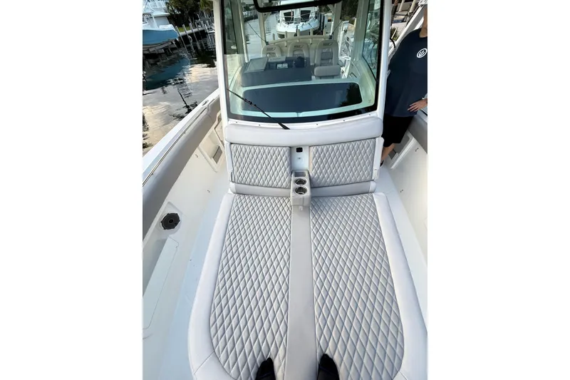 Slide: The Image of 2023 Boston Whaler 380 Outrage boat interior with diamond-stitched seating and cup holders. - 11