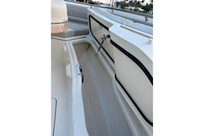 Slide: The Image of 2023 Boston Whaler 380 Outrage boat storage compartment with cushioned seating. - 15