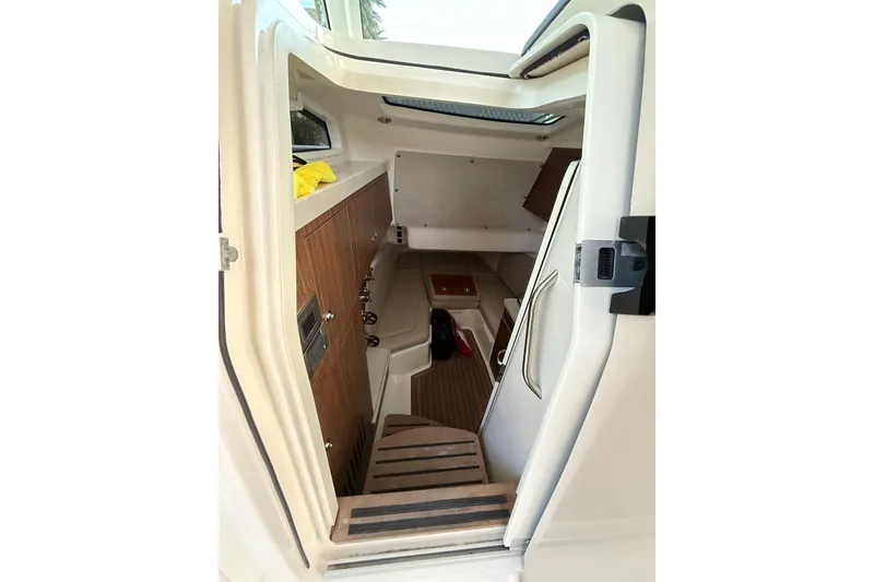 Slide: The Image of Interior cabin of 2023 Boston Whaler 380 Outrage, featuring wood accents and compact design. - 17