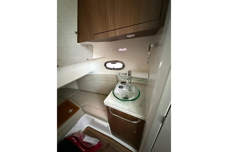 Slide: The Image of Interior of 2023 Boston Whaler 380 Outrage, featuring a compact sink and seating area. - 19