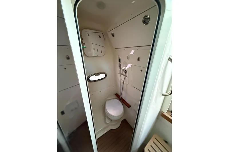 Slide: The Image of 2023 Boston Whaler 380 Outrage bathroom interior with toilet and mirror. - 20